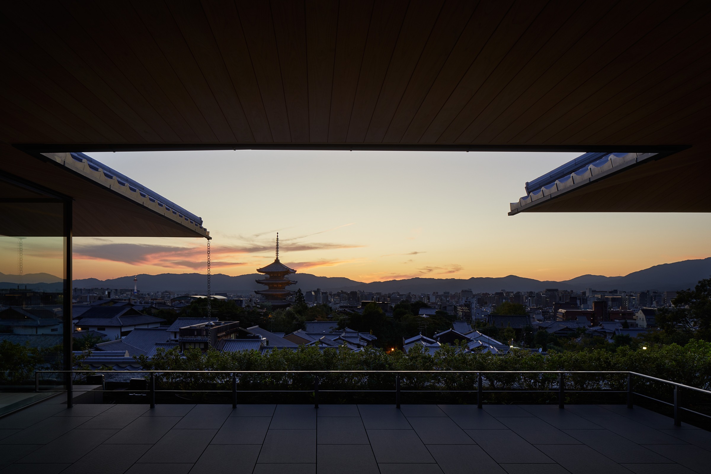 A terrace at Park Hyatt Kyoto facing Kyoto rooftops and Yasaka Pagoda at sunset